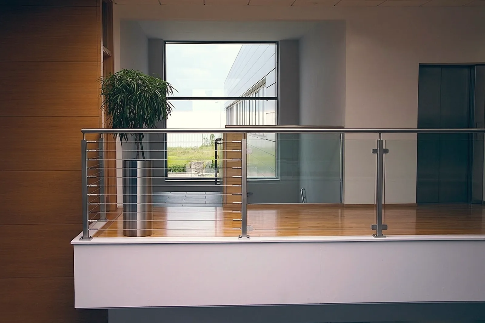Cable railing and glass railing on neighboring decks