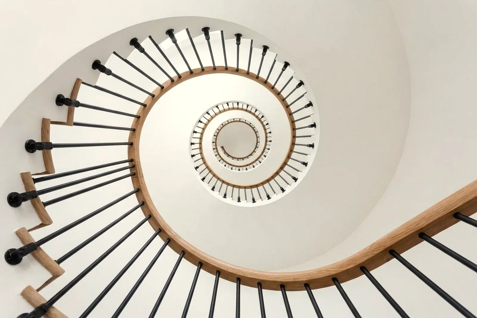 Staircase with oak handrail and new black iron balusters